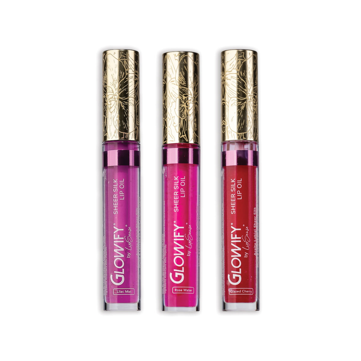 Glowify Sheer Silk Lip Oil Collection by SeneGence: Three clear lip-oil tubes in violet lilac, hot pink and cherry red, each with an orchid-engraved gold cap.