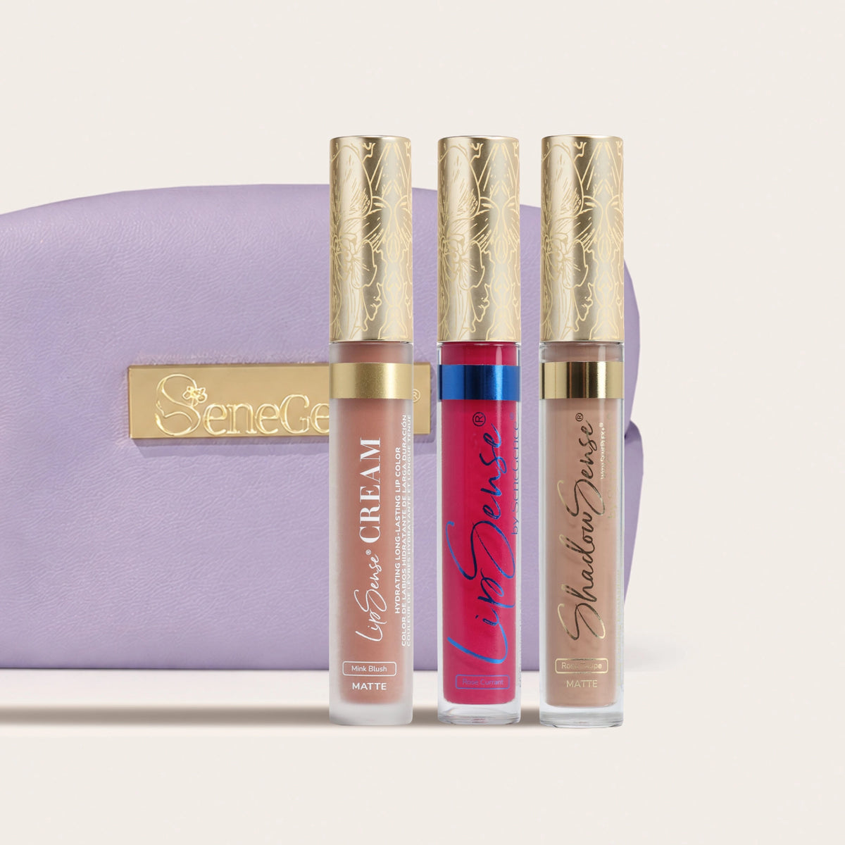 Limited-Edition Blushed Rose Collection by SeneGence: Three gold-capped tubes in neutral pink, rosy red and taupe beside a lavender pouch.
